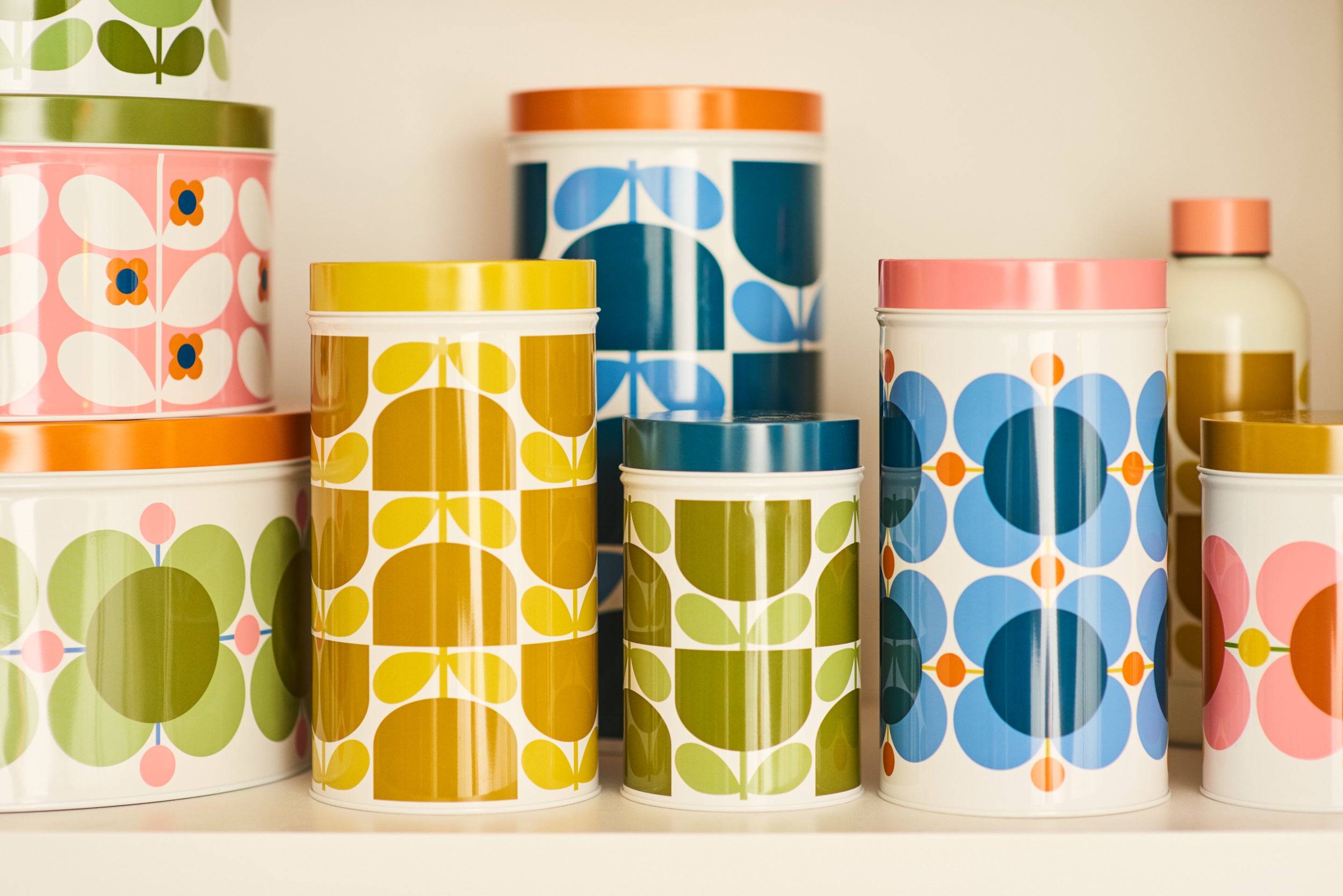 Ceramic kitchen storage jars and utensil pots in retro patterns on a shelf