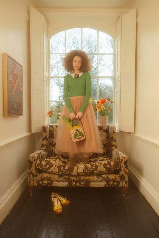 Model standing on floral chair with Orla Kiely bee bag 