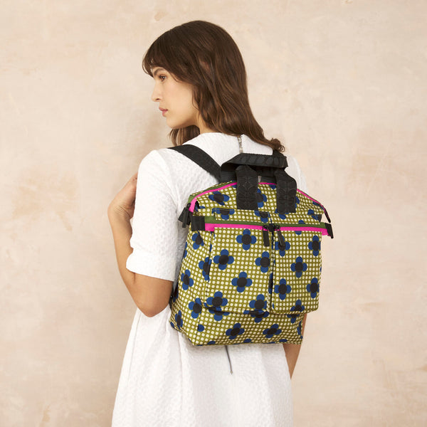 Model wearing the Axis Medium Backpack in Flower Polka Dot Olive pattern by Orla Kiely