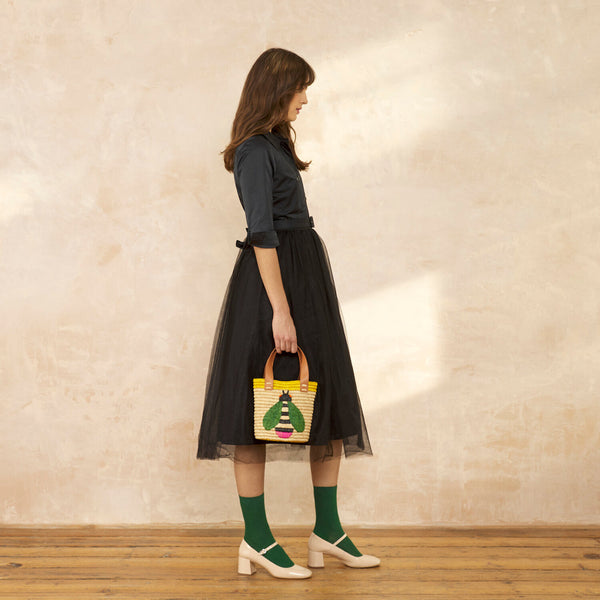 Model wearing the Sunday Mini Tote in Bug Yellow pattern by Orla Kiely