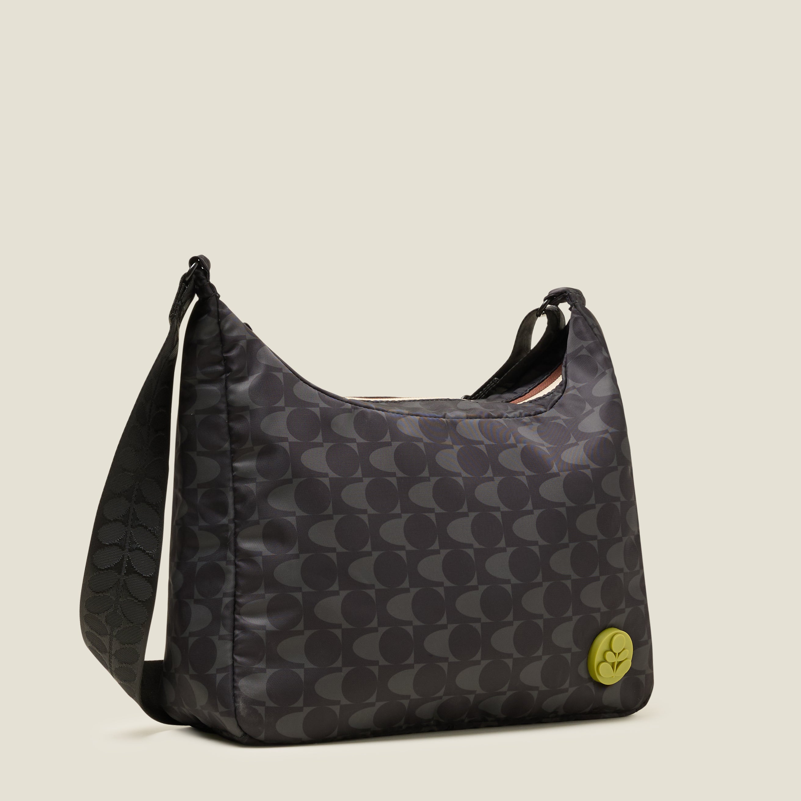 Side view of crossbody bag in a black and grey pattern. The handbag features a lime stem logo detail.
