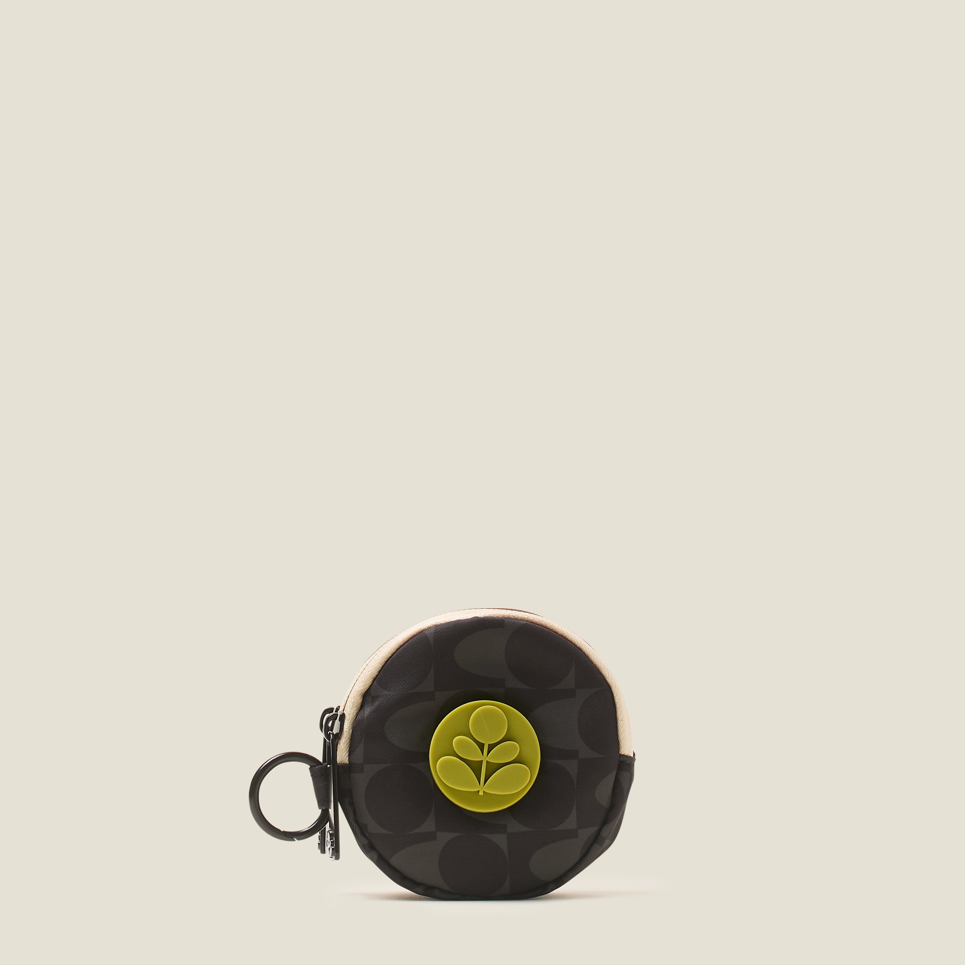 Round black coin purse with a green Orla Kiely Stem logo, featuring a ring clip on a beige background