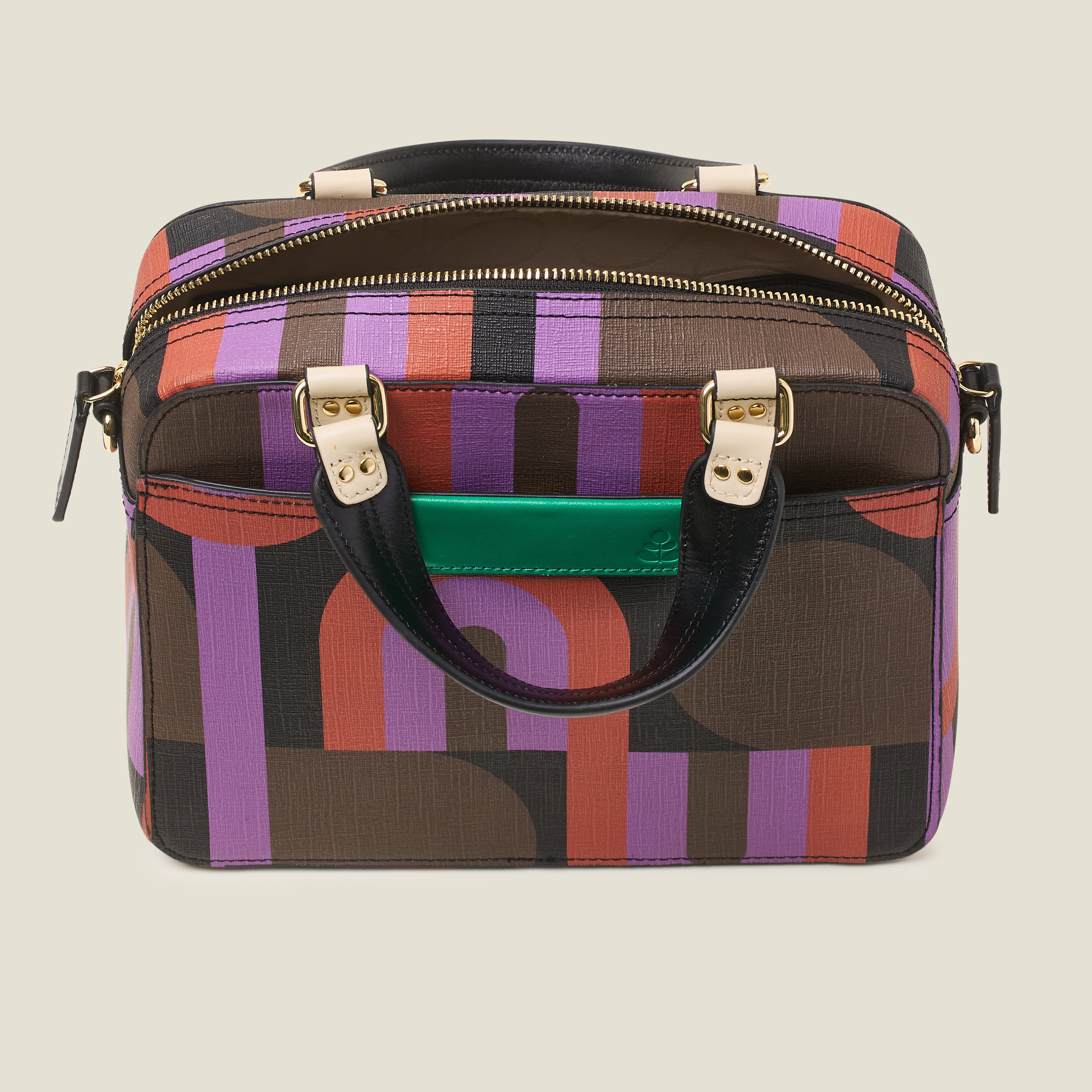Top view of square handbag in a retro purple, red and brown print, featuring grab handles, zip closure and green leather branding