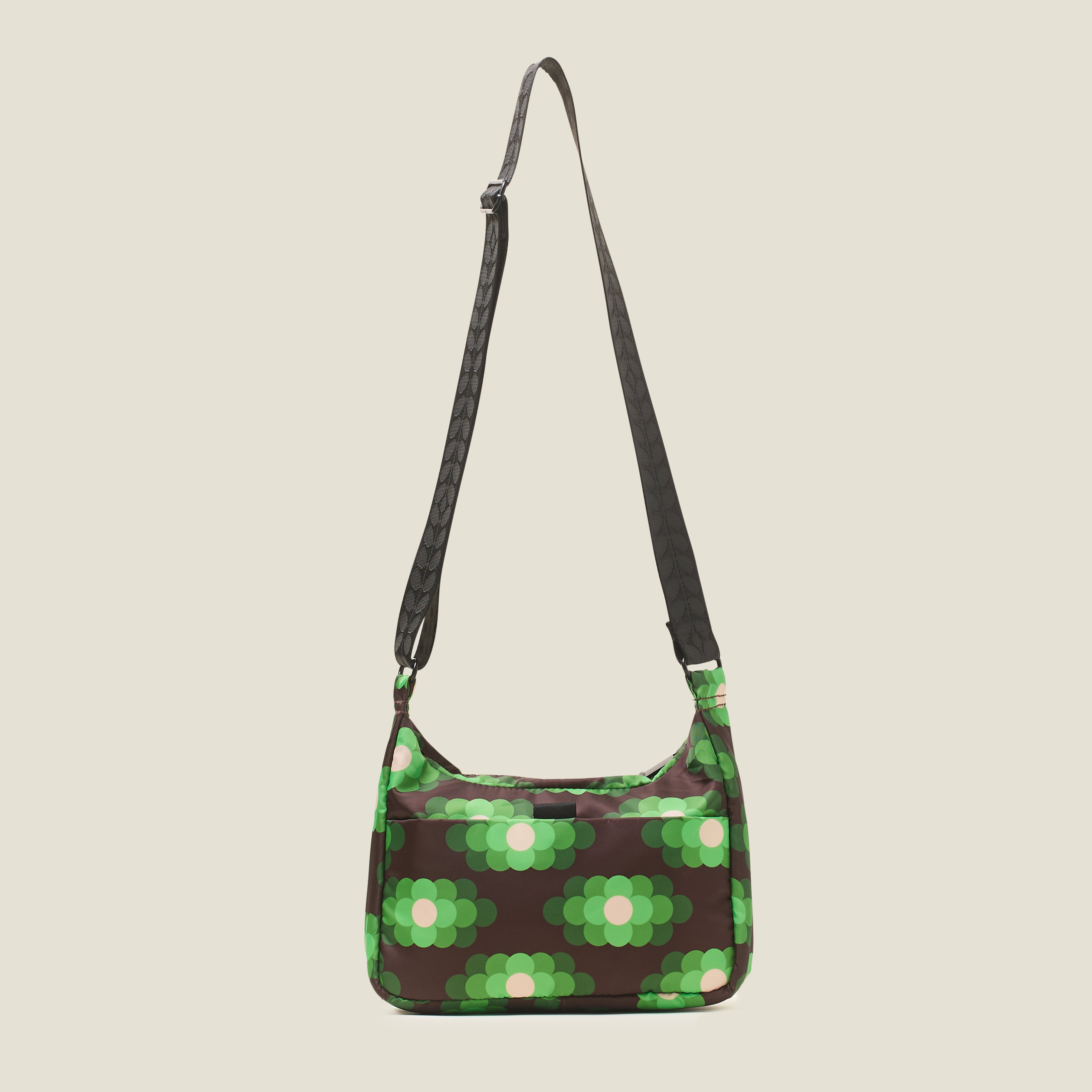 The back view of small hobo bag with neon green floral pattern, back pocket and black adjustable strap.