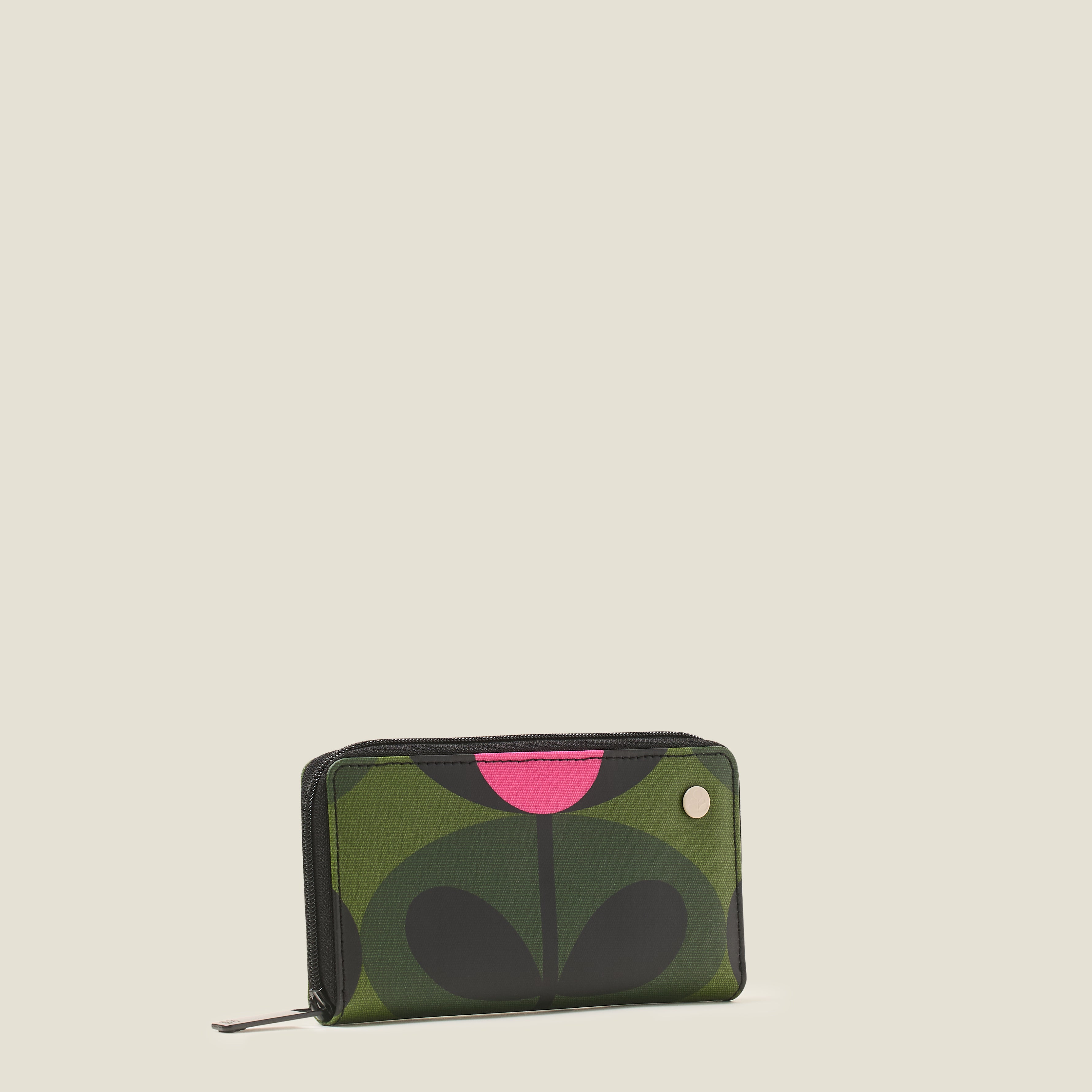 Side view of women's large wallet in green print with pink in coated cotton and zip closure.