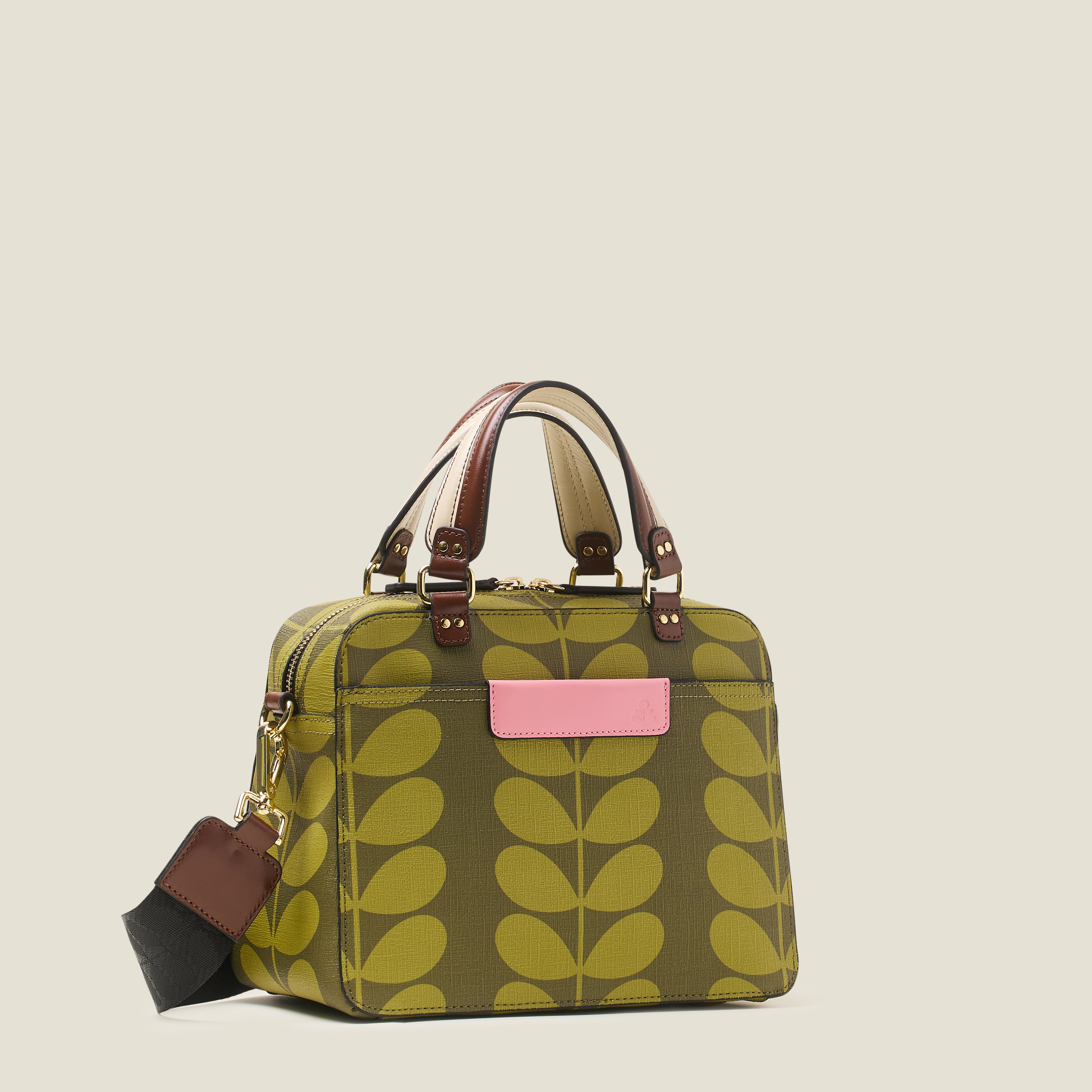 Side view of a medium square handbag with green leaf pattern, featuring leather grab handles and pink branding.