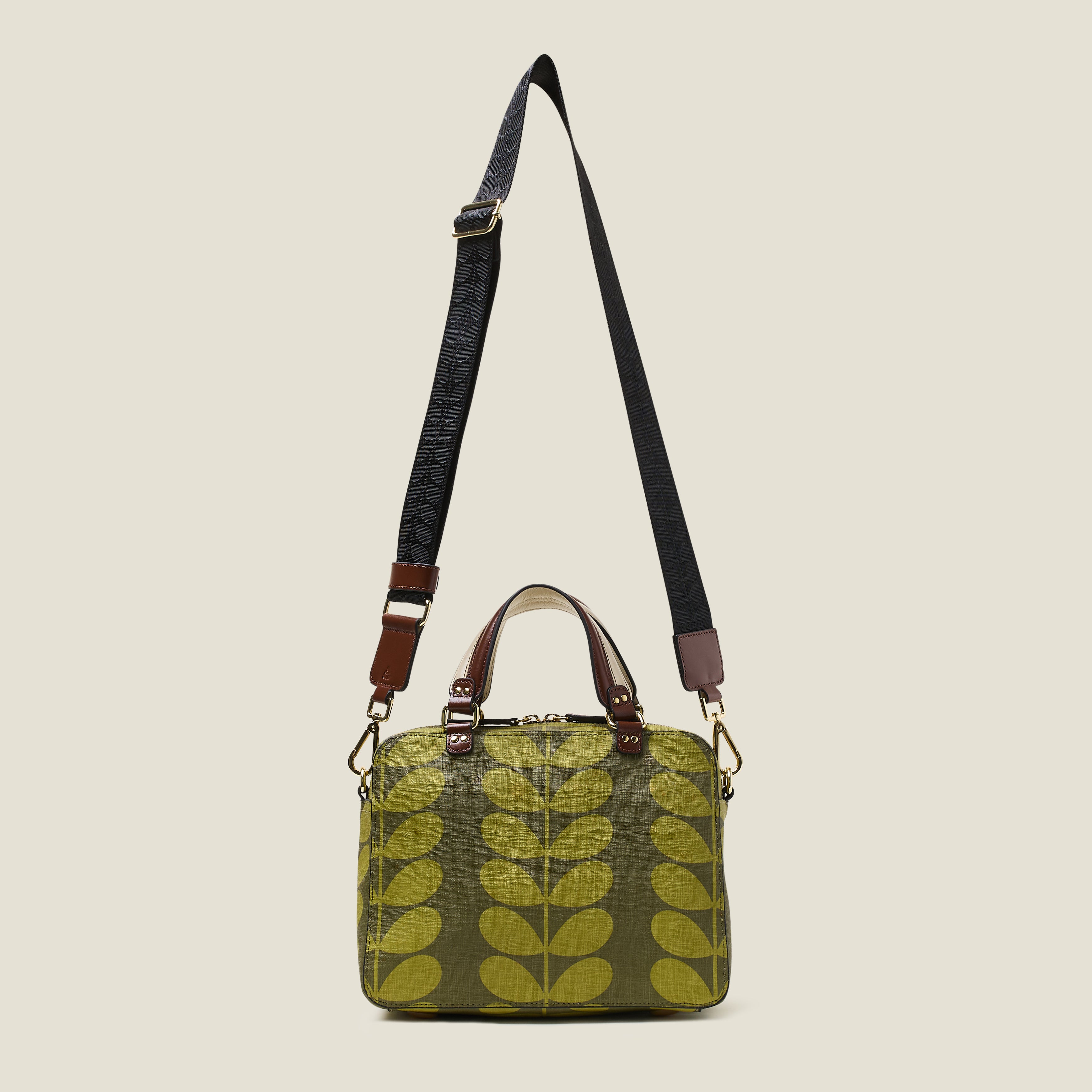 Back view of a medium square handbag with green leaf pattern, featuring leather grab handles and shoulder strap at full length.