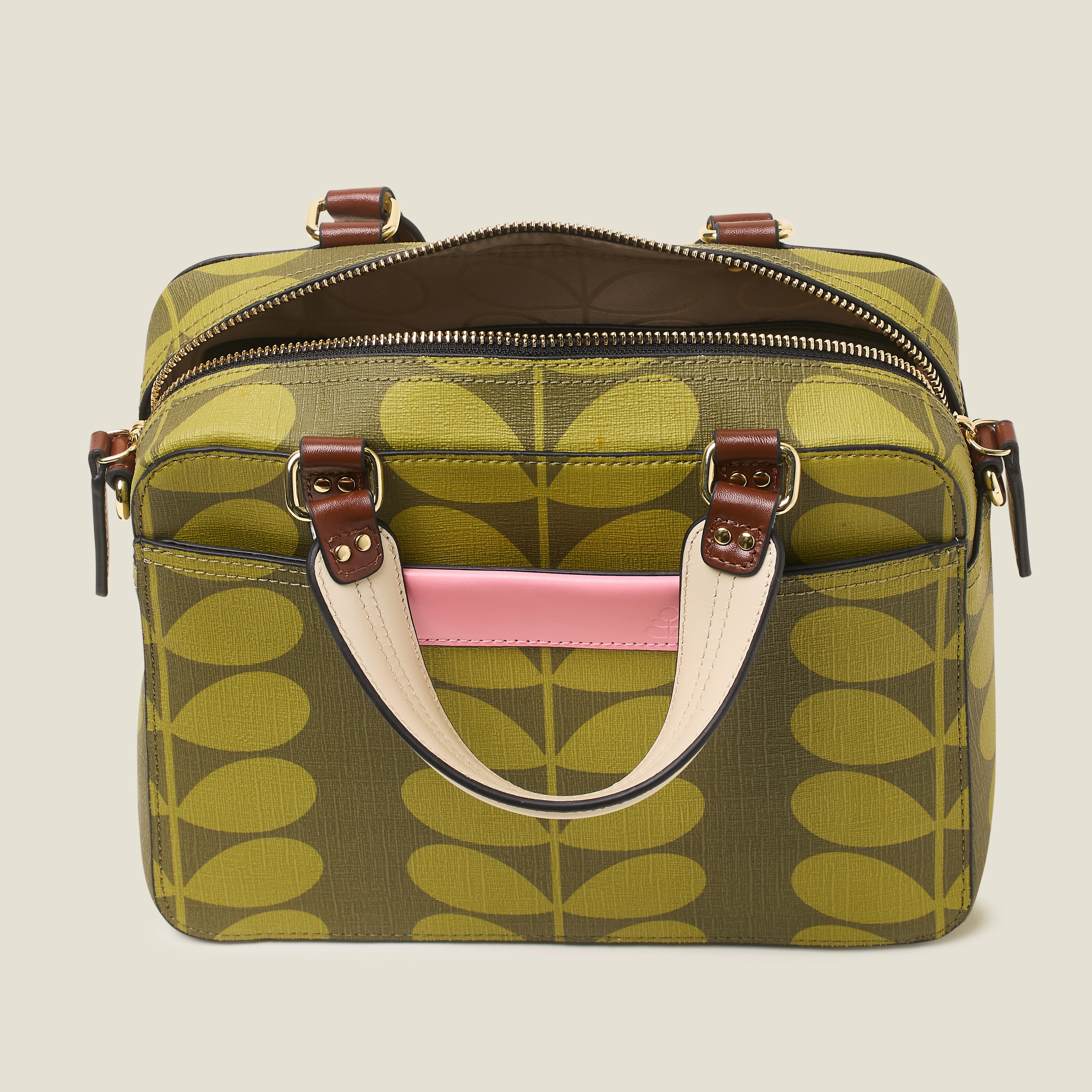 Top open view of zipper on a medium square handbag with green leaf pattern, featuring leather grab handles and pink branding.