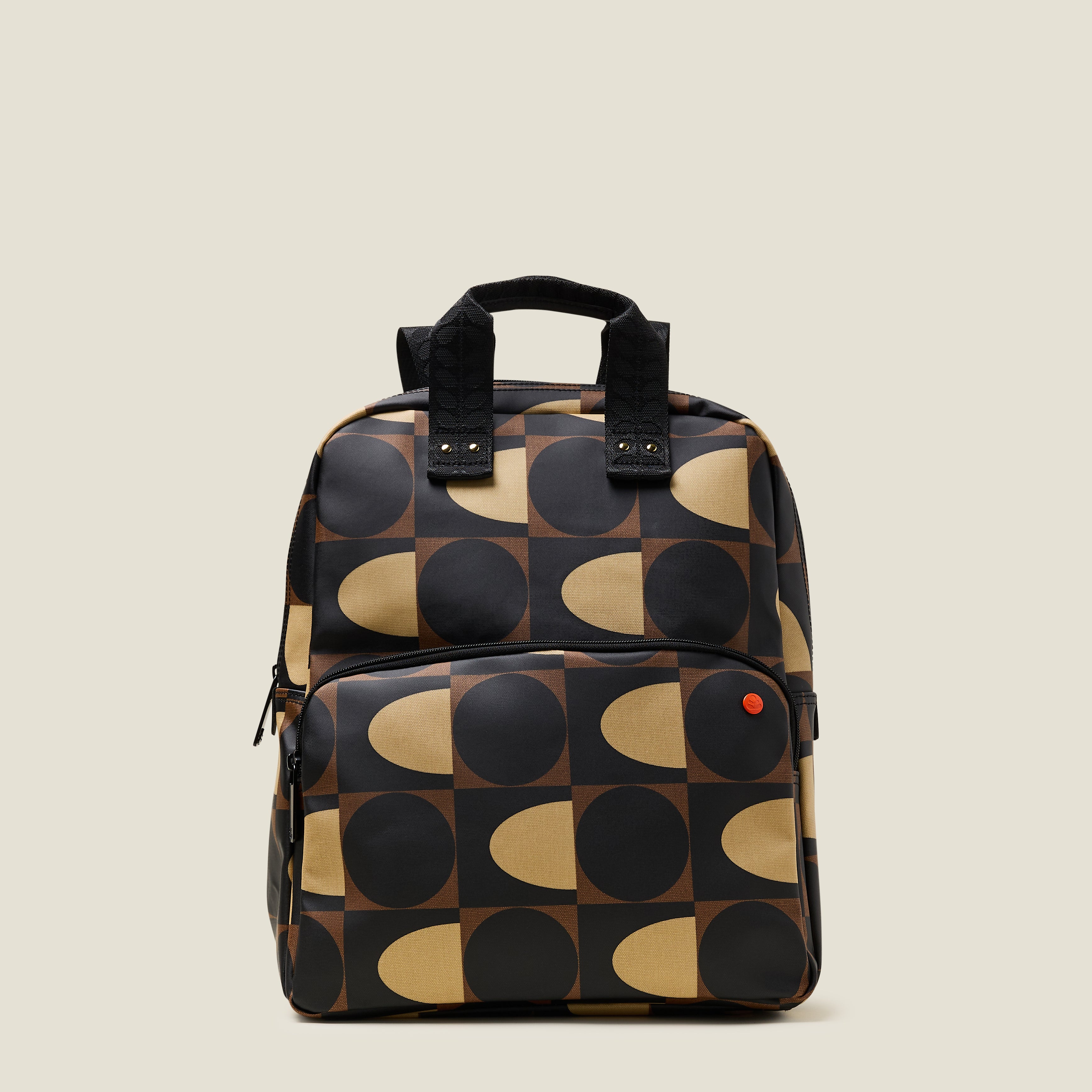 Front view of the Lotta Backpack in a brown and cream dot and squares print featuring a zipped front pocket and branded grab handles.