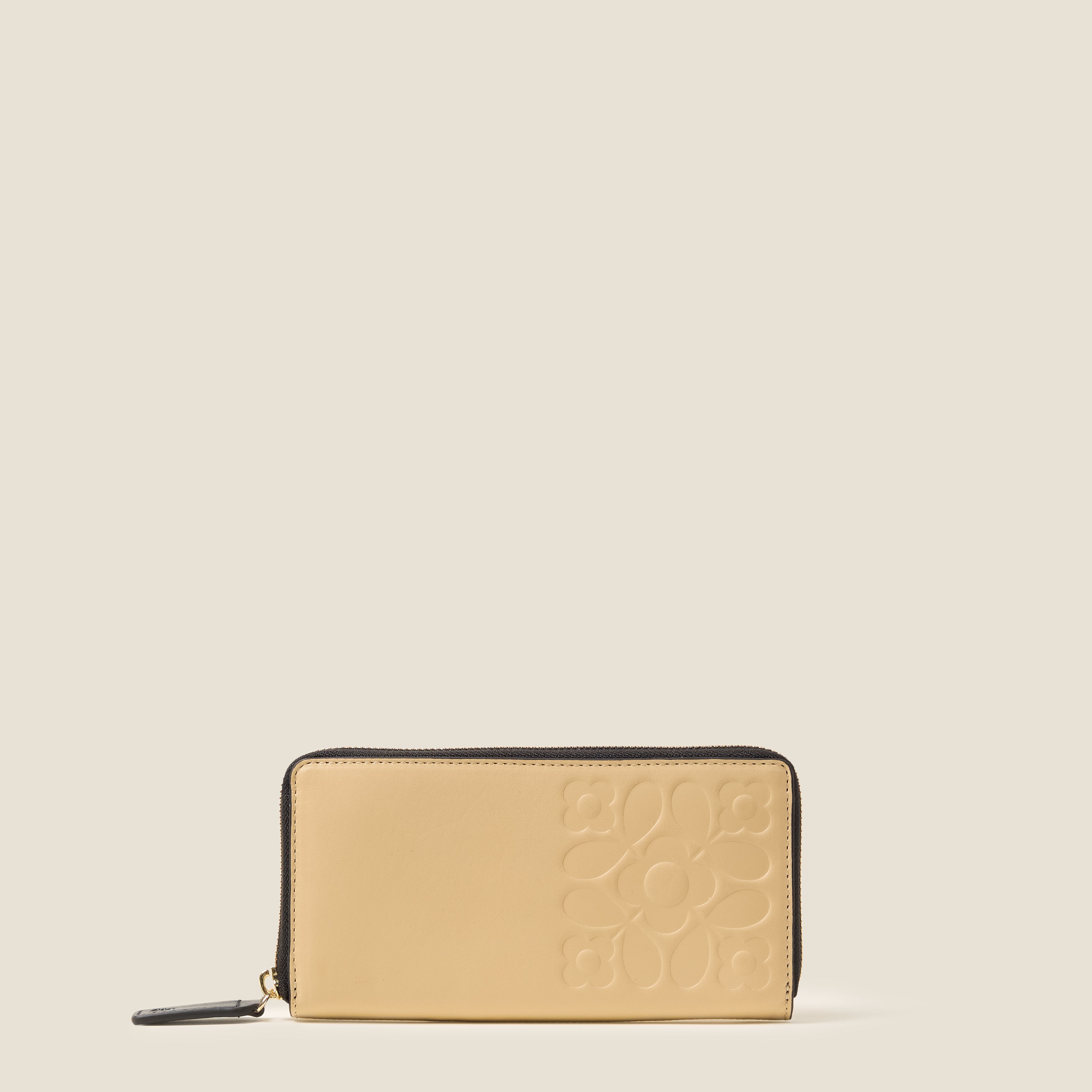 Front view of a cream leather wallet with black zipper, featuring an Orla Kiely embossed pattern.