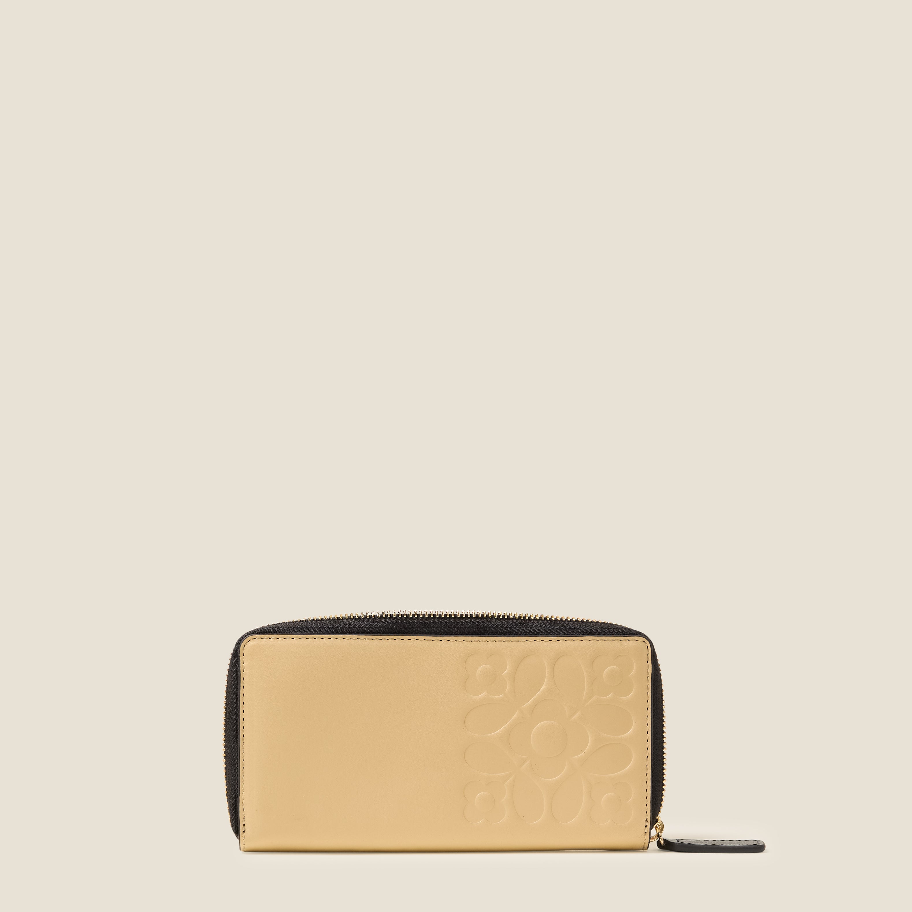 Back view of a cream leather wallet with black zipper, featuring an Orla Kiely embossed pattern.