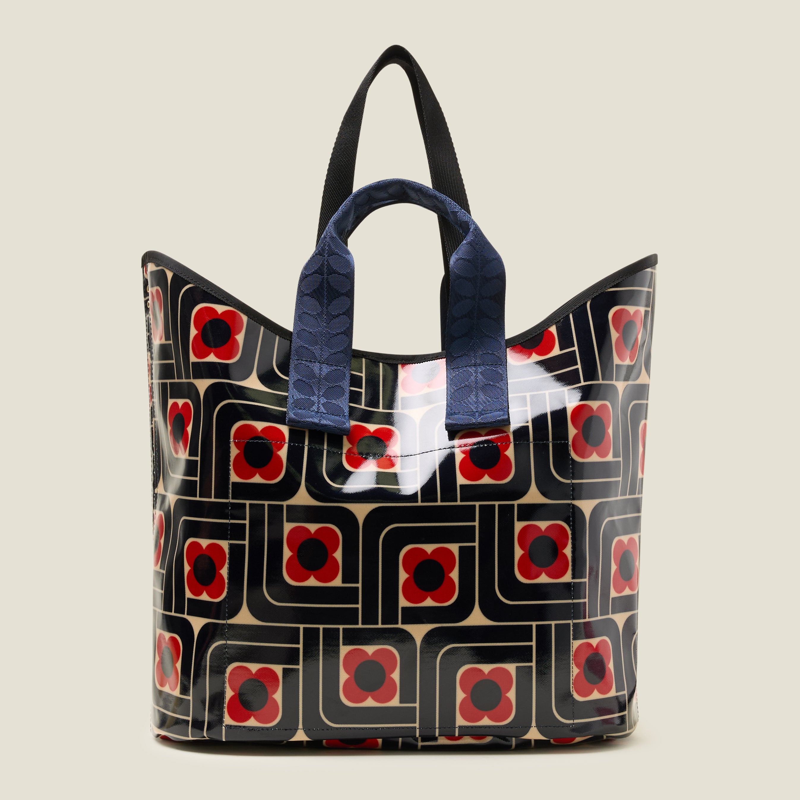 Back view of large patterned tote bag with red, navy and cream woodblock design, with navy grab handles.