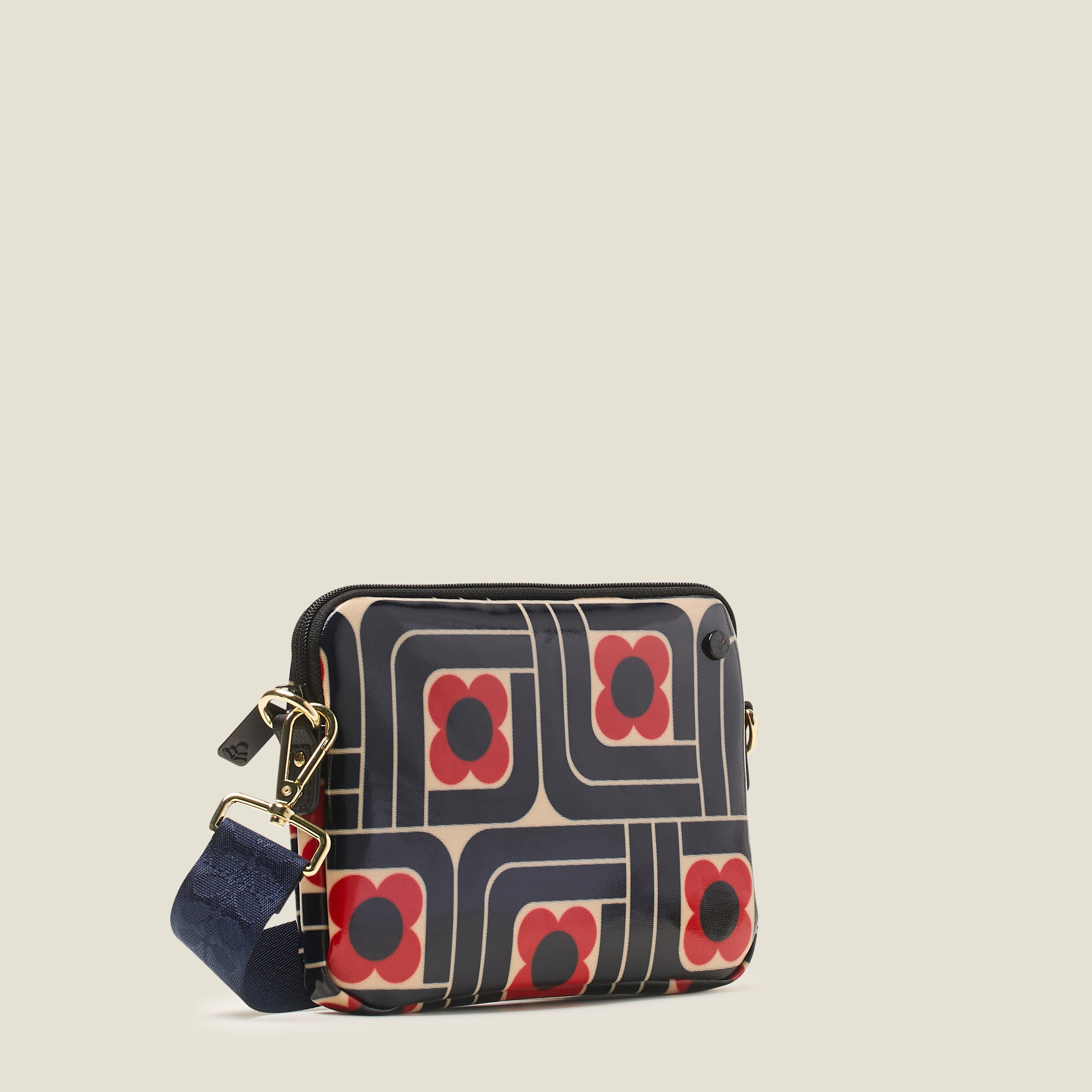 Side view of the slim crossbody patterned handbag in navy, red and cream, with navy shoulder strap.