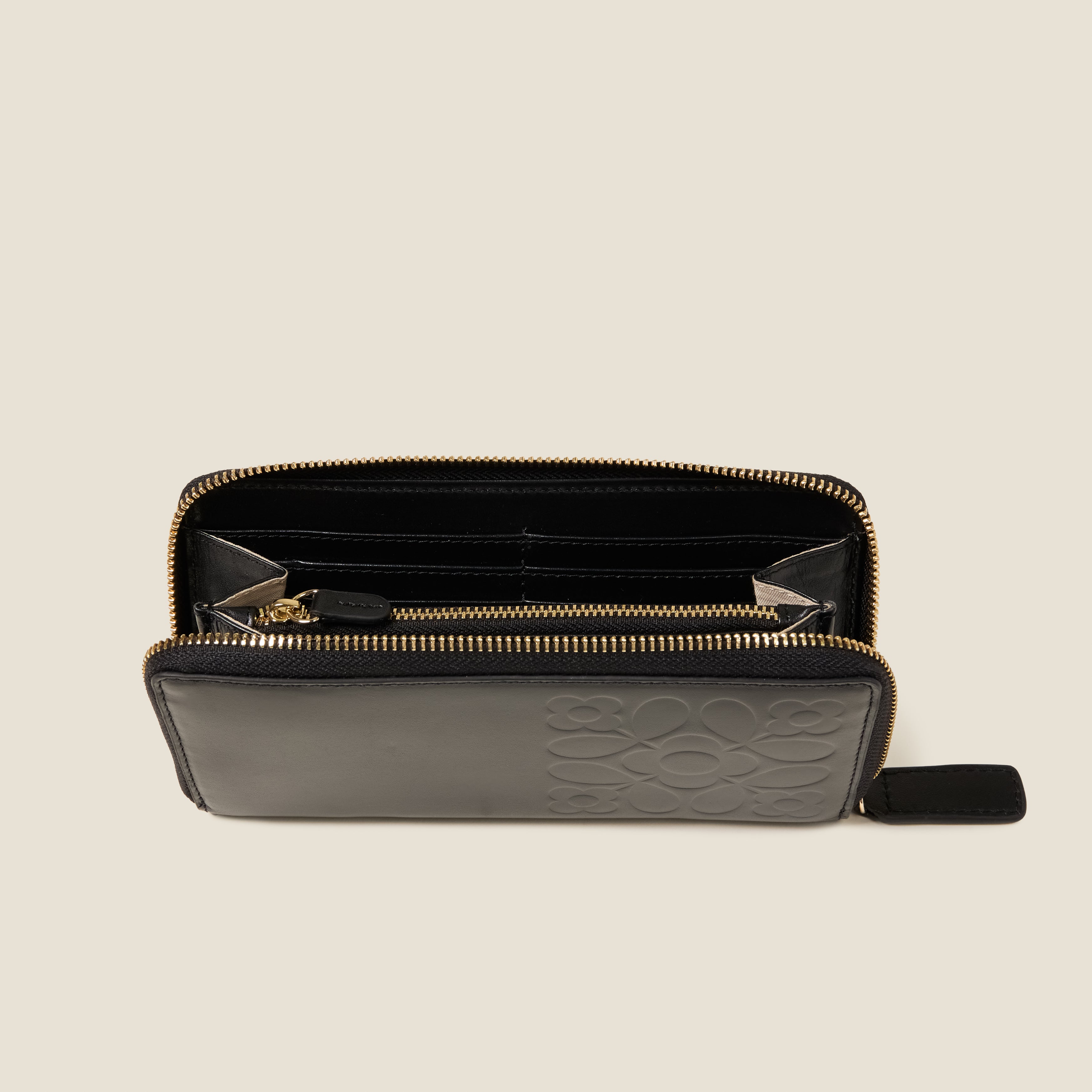 Open top view of the Forget Me Not Wallet in black leather women's wallet with Orla Kiely pattern embossing and zip closure.