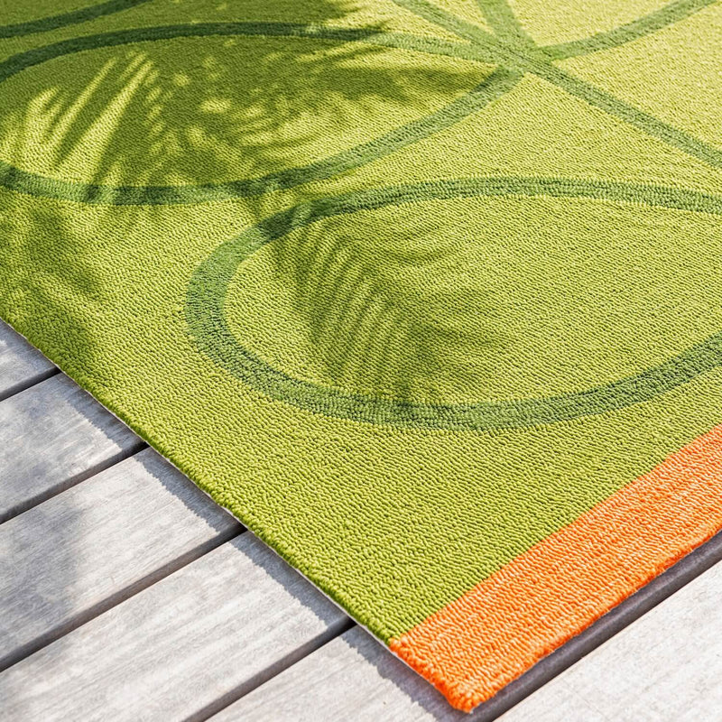 Lifestyle image of seagrass green and orange Orla Kiely outdoor rug