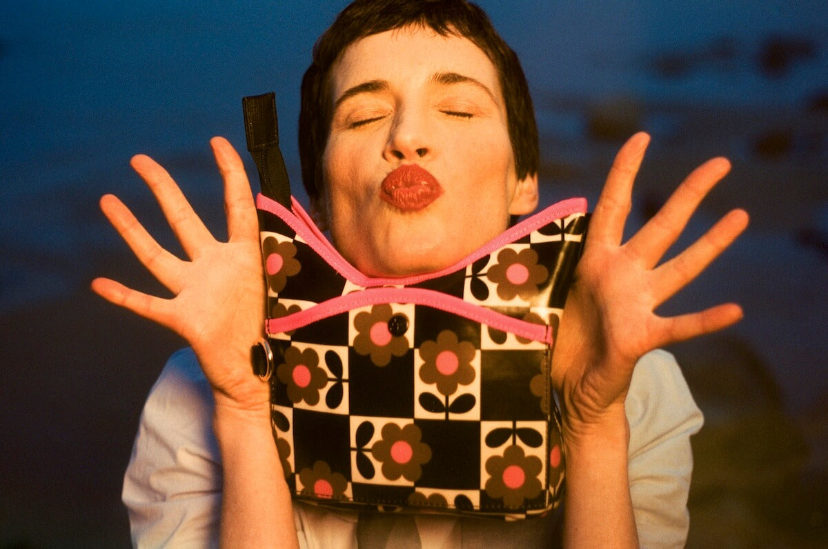 Model making a funny face with a glossy Orla Kiely bag 