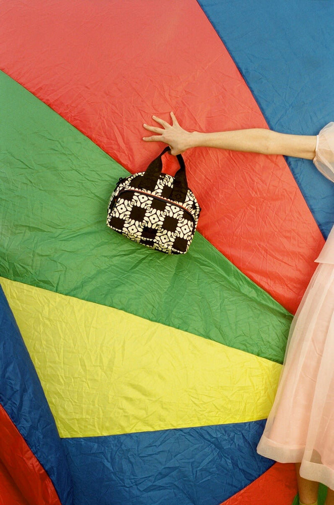 Model holding Orla Kiely bag for good in front of parachute