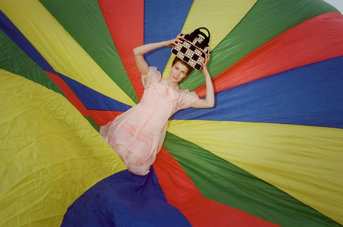 Model on parachute holding Orla Kiely bag for good over her head