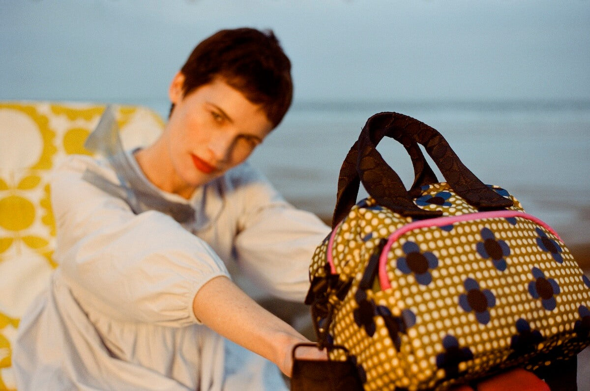 Orla Kiely radial handbag in polka dot olive with model in background