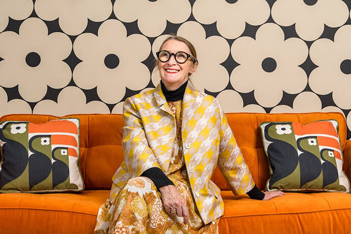 Orla Kiely smiling on a sofa with toucan cushions