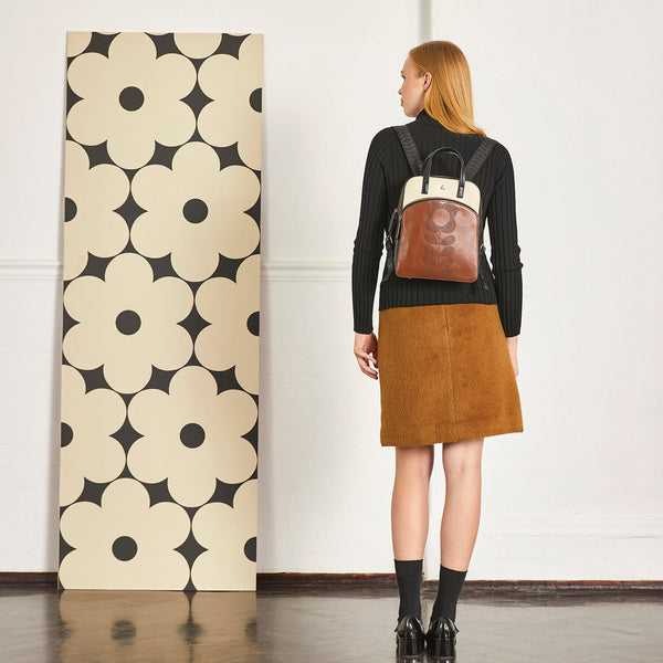 Model wearing an Orla Kiely Emilia Leather Backpack in Tonal Punched Flower