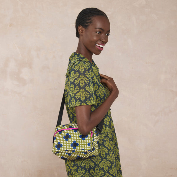 Model wearing the Angle Camera Bag in Flower Polka Dot Olive pattern by Orla Kiely