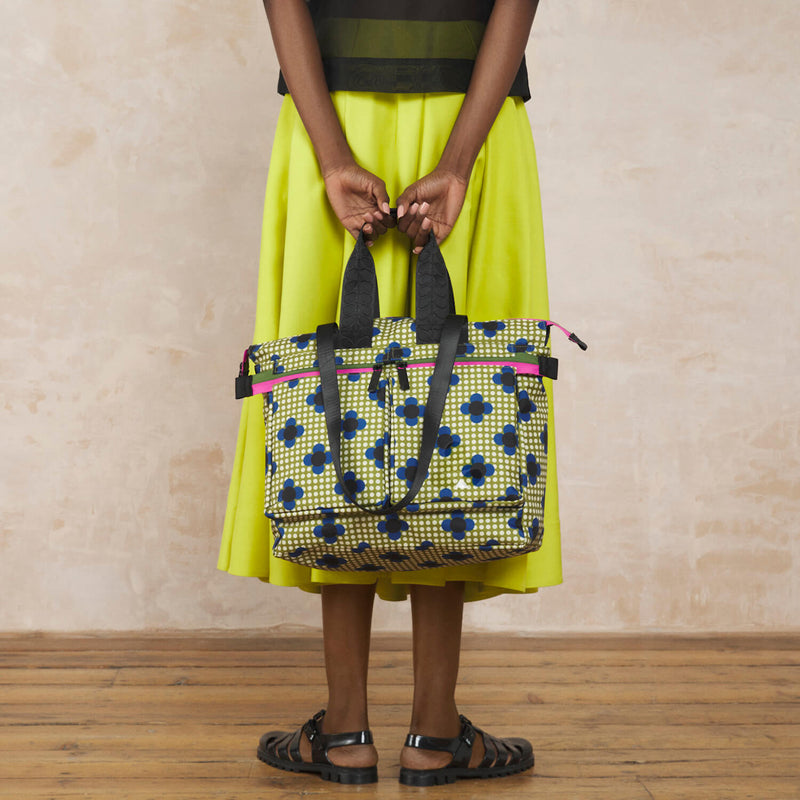 Model wearing the Axis Tote Bag in Flower Polka Dot Olive pattern by Orla Kiely