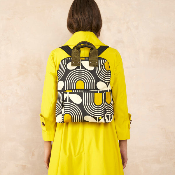 Model wearing the Bestie Backpack in Giant Striped Tulip Noir pattern by Orla Kiely
