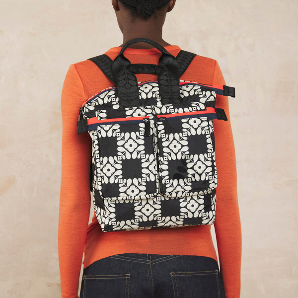 Model wearing the Axis Medium Backpack in Lattice Flower Tile Onyx pattern by Orla Kiely