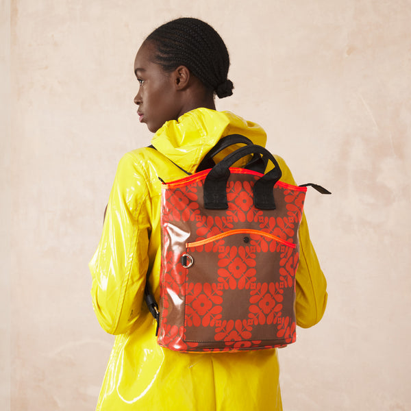 Model wearing Carry Backpack in Lattice Flower Tile Conker pattern by Orla Kiely