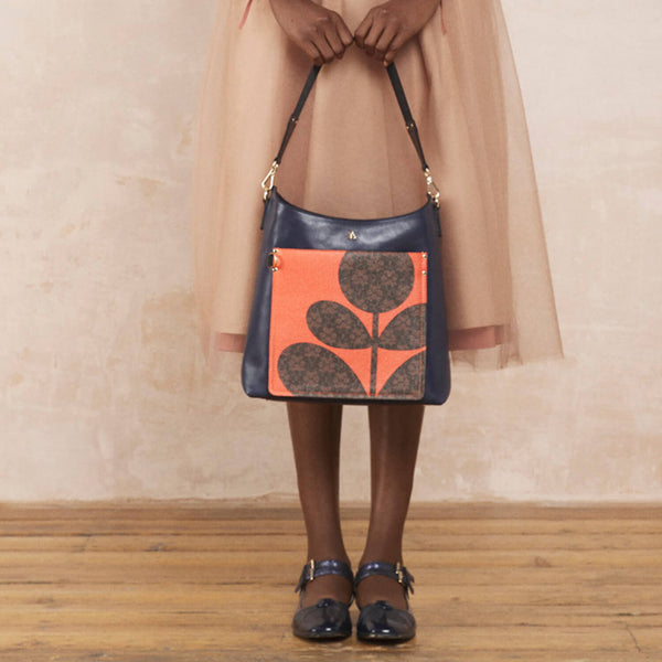 Model wearing the Carrymax Bucket Bag in Navy Puzzle Flower Emblem pattern by Orla Kiely