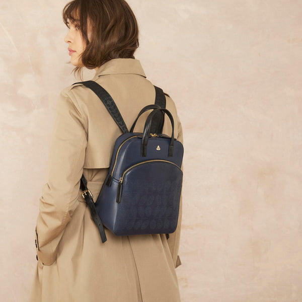 Model wearing the Emilia Backpack in Navy Punched Flower pattern by Orla Kiely
