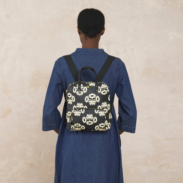 Model wearing the Buddy Backpack in Posey Flower Midnight pattern by Orla Kiely