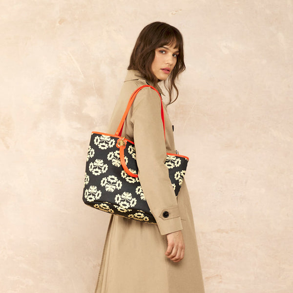 Model wearing the Smile Tote Bag in Posey Flower Midnight pattern by Orla Kiely