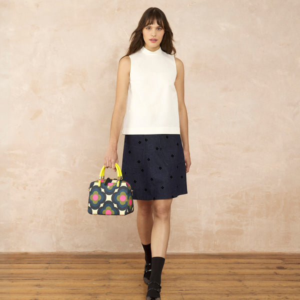Model wearing the Block Medium Handbag in Radial Flower Rockpool pattern by Orla Kiely