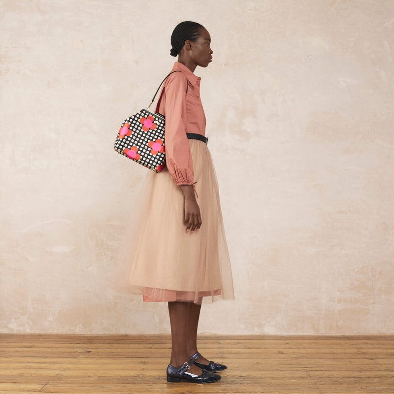 Model wearing the Jenny D Handbag in Fuchsia Flower Polka Dot pattern by Orla Kiely