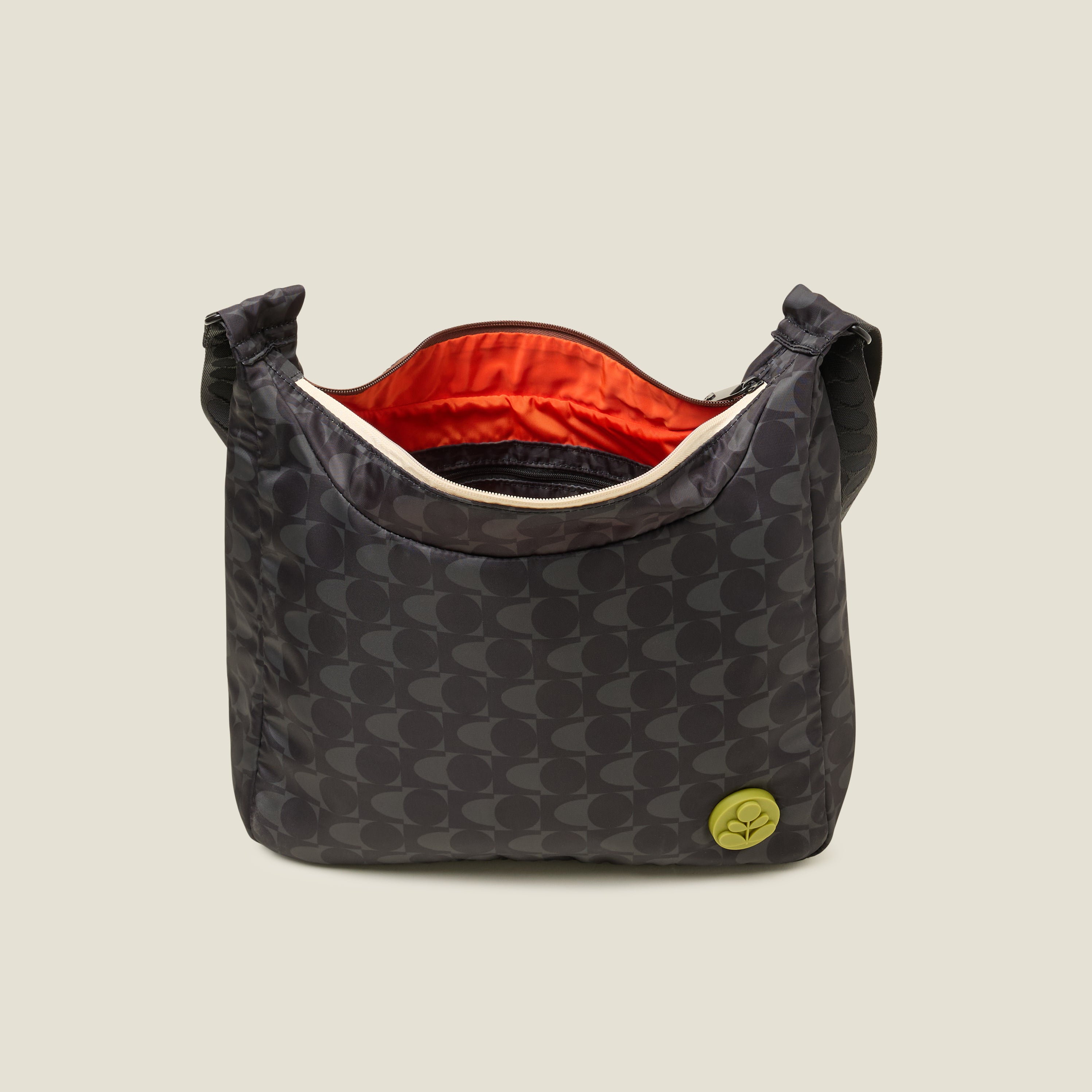 Top view of crossbody bag in a black and grey pattern. with zipper open to reveal the inside zip pocket and orange lining. The handbag features a lime stem logo detail.