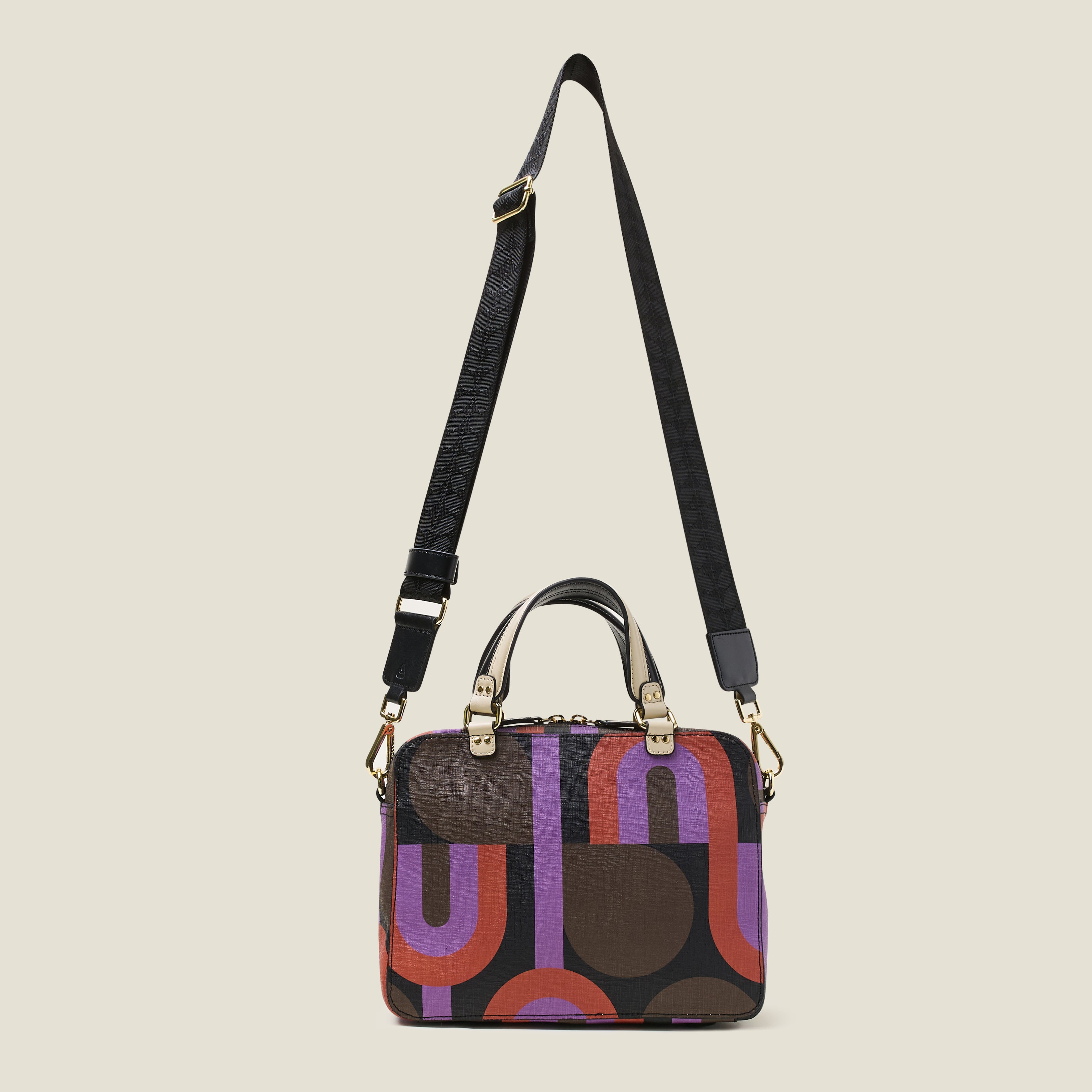 Front view of a square handbag in a retro purple, red and brown print, featuring grab handles, and crossbody strap at full length.