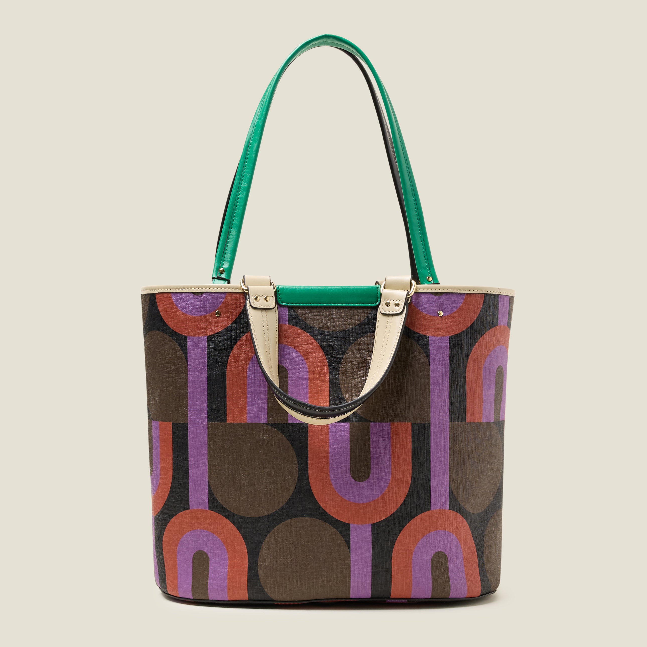 Back view of a large tote bag with purple, red, brown and black retro inspired pattern, featuring leather grab handles and green branding.