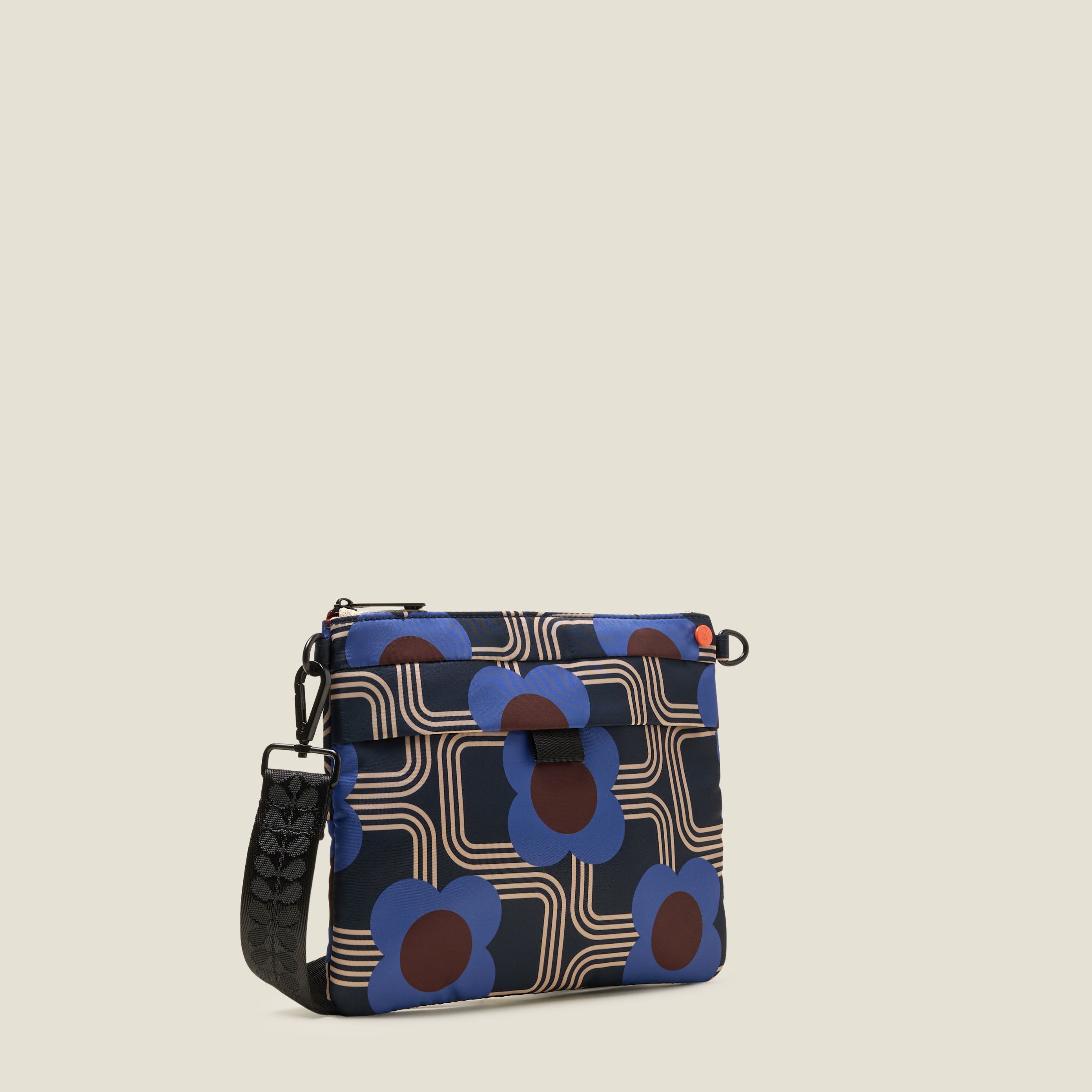 Patterned shoulder bag with blue and brown retro floral design, black webbing strap on a beige background