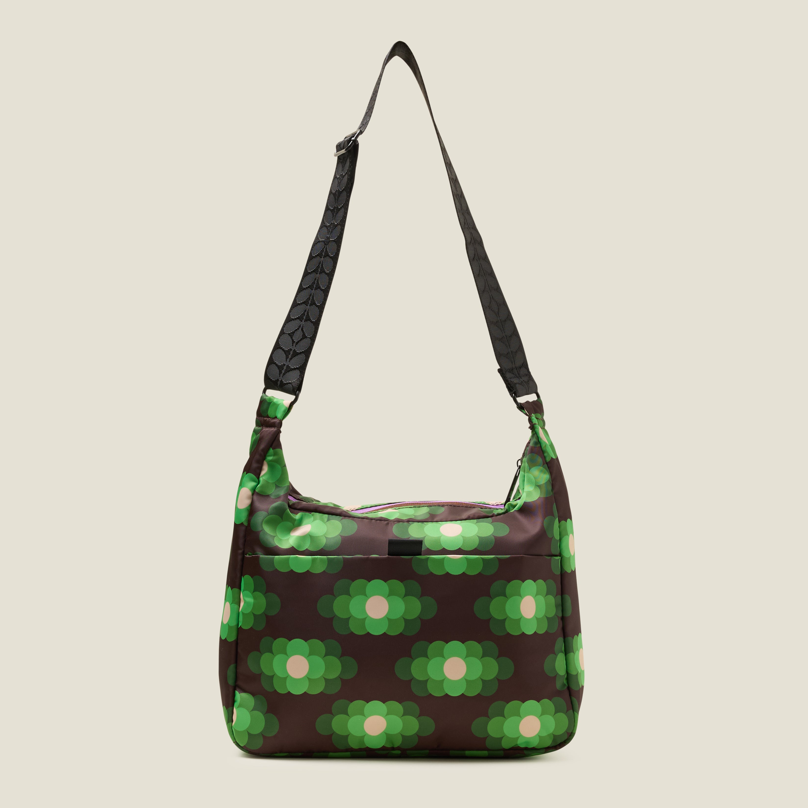 Back view of crossbody bag in a neon green floral pattern. Adjustable shoulder strap and back slip pocket with tab.