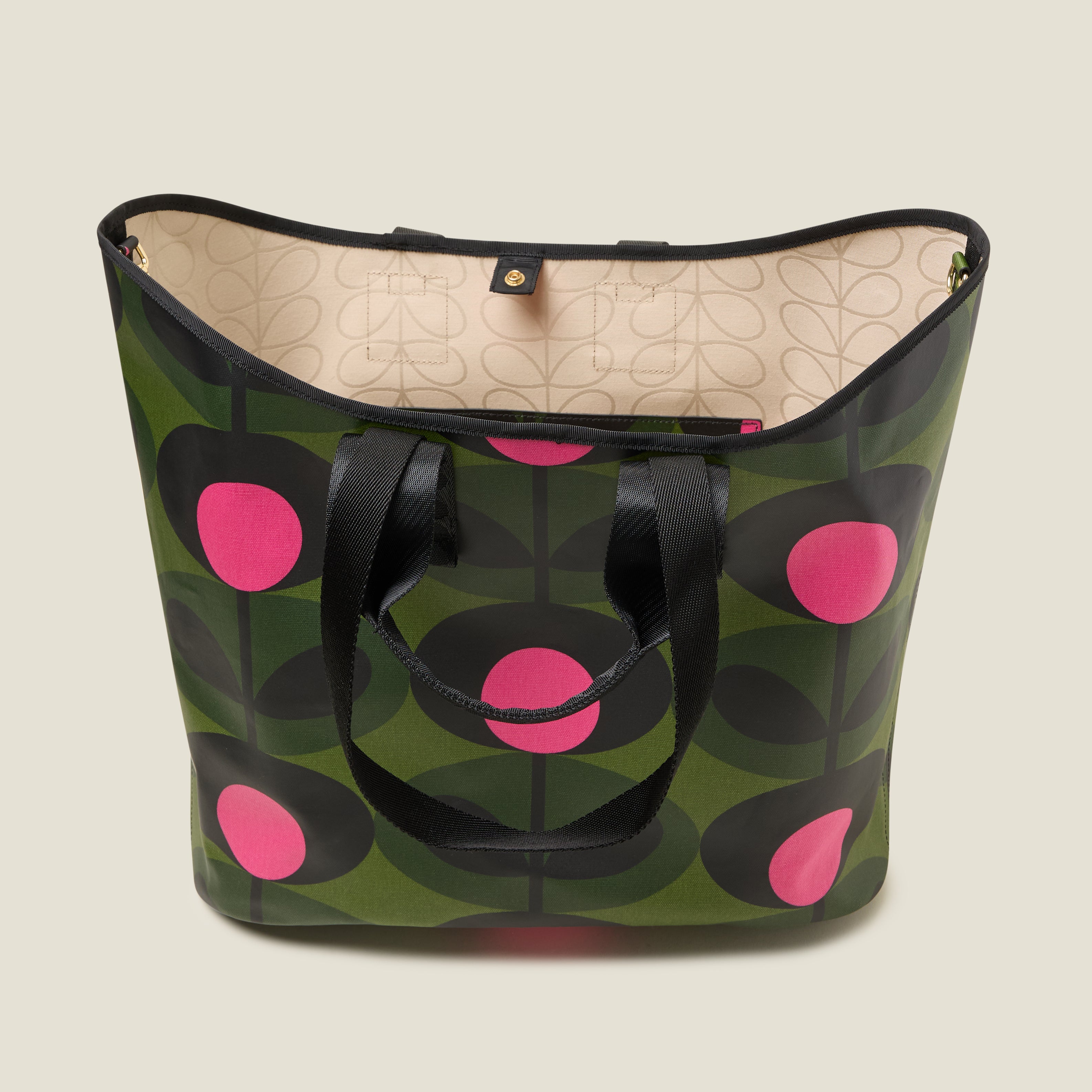 The top view of a  large green tote bag with pink and black floral pattern with Orla Kiely webbing handles and shoulder strap. Inside features a zip pocket and snapper fastening.