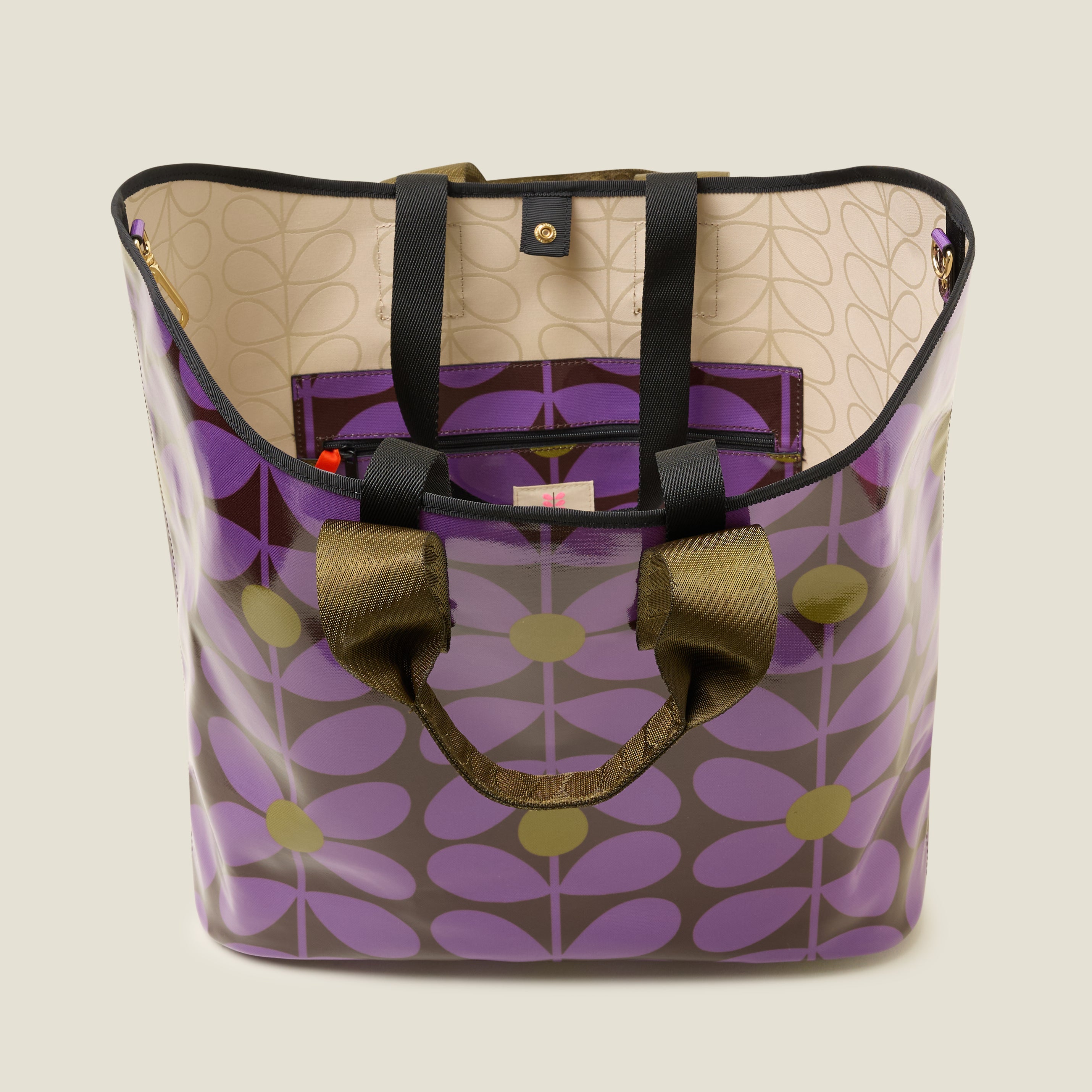 Top view of large patterned tote bag with purple, brown and green floral stem print design, inside features a zip pocket and snapper fastening.