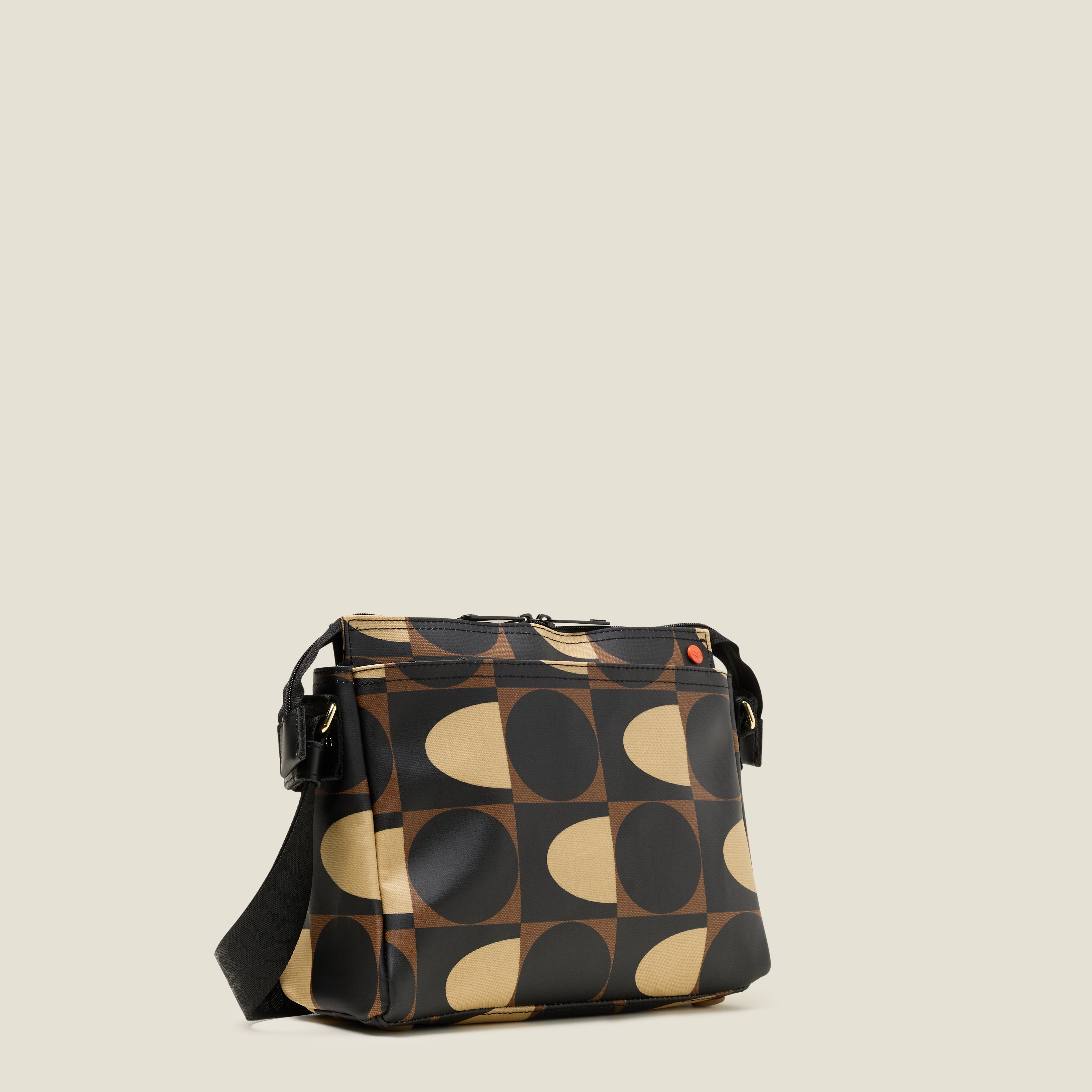 Side view of the Fielder Crossbody bag in a brown and cream retro pattern, with front pocket and zip closure.
