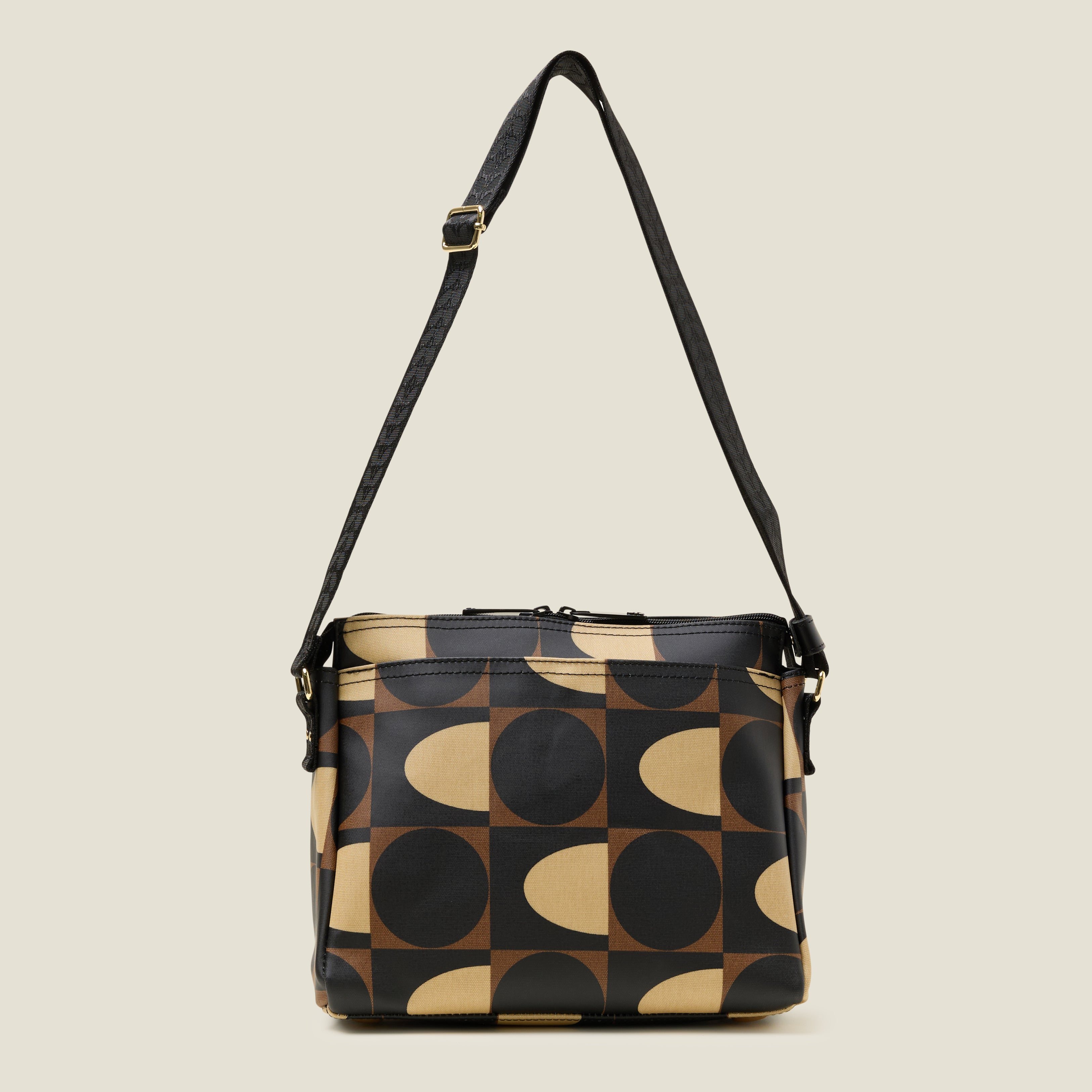 Front view of the Fielder Crossbody bag in a brown and cream retro pattern, with front pocket, zip closure and strap at full length.