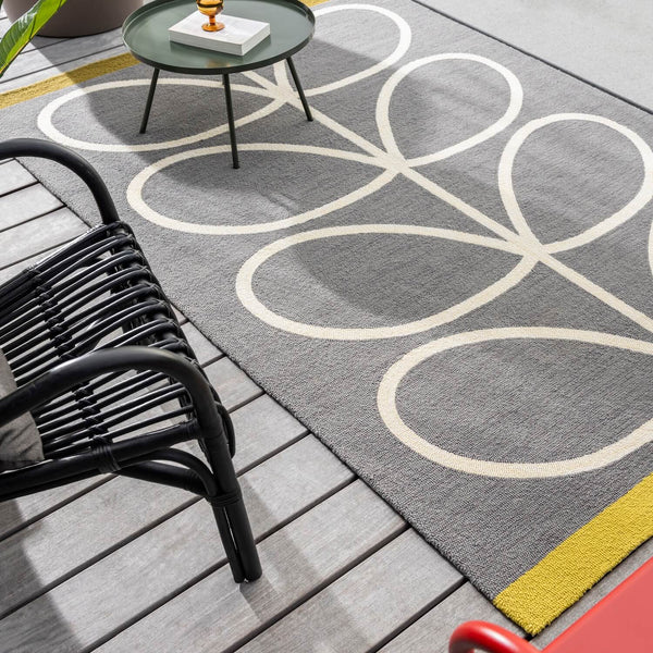 Lifestyle image of slate grey and yellow Orla Kiely stem outdoor rug