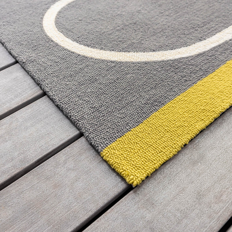 Lifestyle image of slate grey and yellow Orla Kiely stem outdoor rug