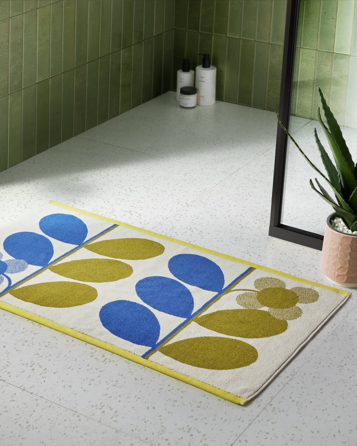 Lifestyle shot of Orla Kiely stem bloom bathmat in blue and fawn colour way