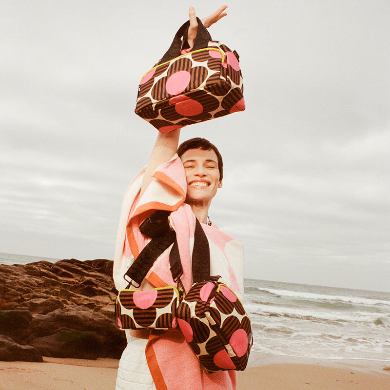 A model wrapped in an Orla Kiely towel with three Orla bags