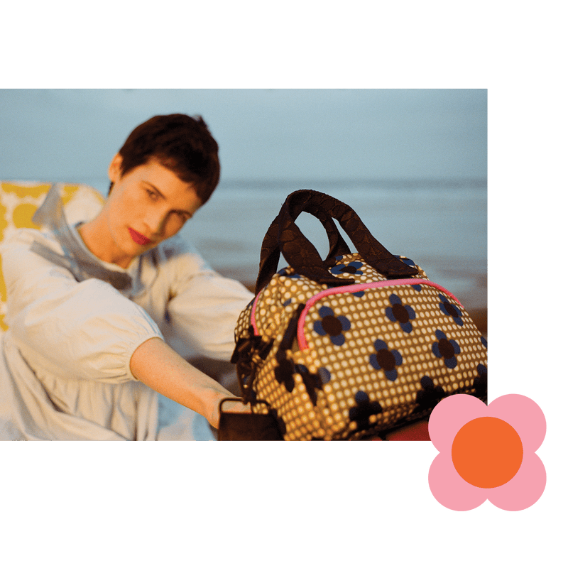 Model holding Orla Kiely floral Radial handbag